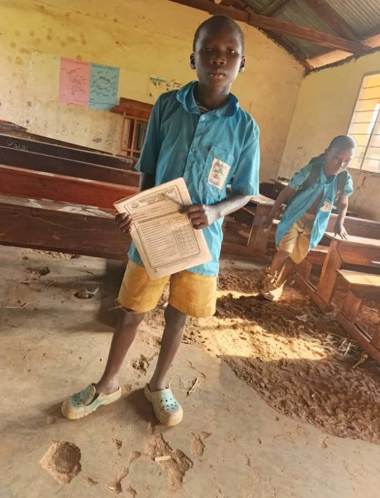 Student standing inside a classroom with a damaged floor