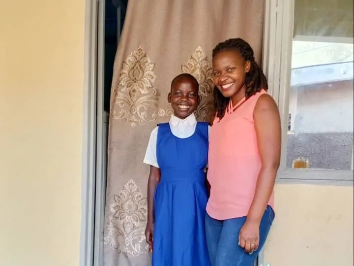 Shining Light Uganda team member with a supported schoolgirl