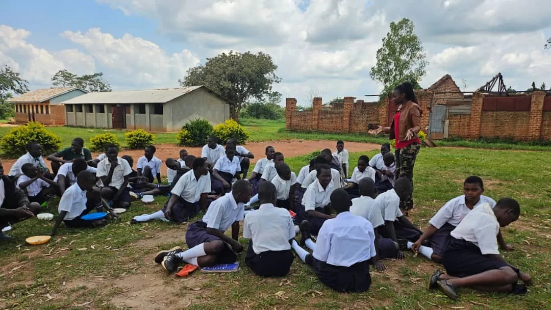 Students seated outside during a school outreach session