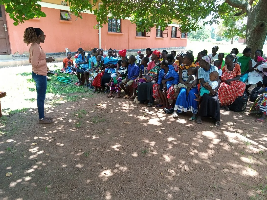 Facilitator leading a community health talk outdoors