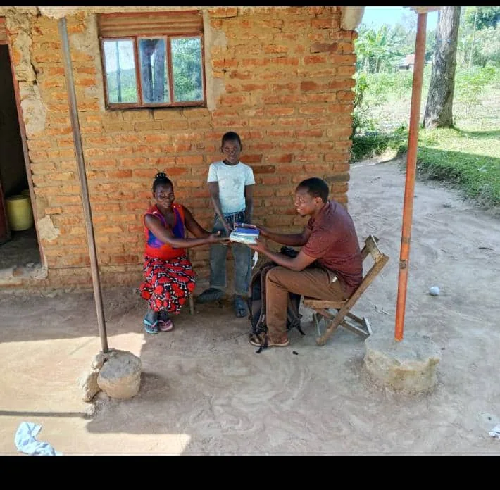 Simon Peter Ogen receiving scholastic materials with his family